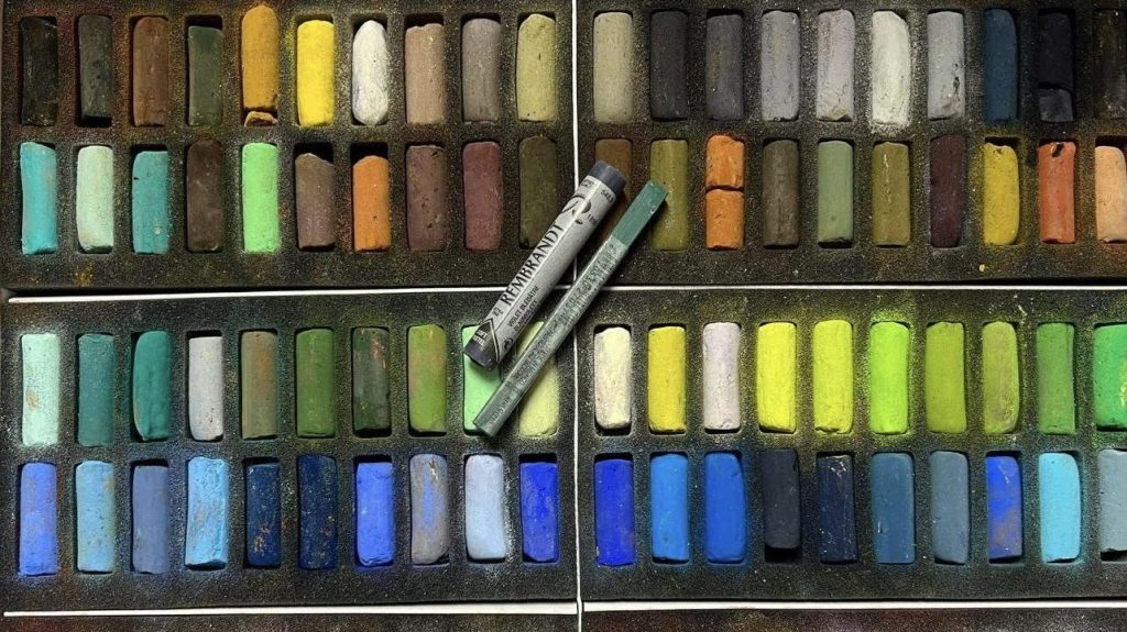 Many different colors of chalk in boxes